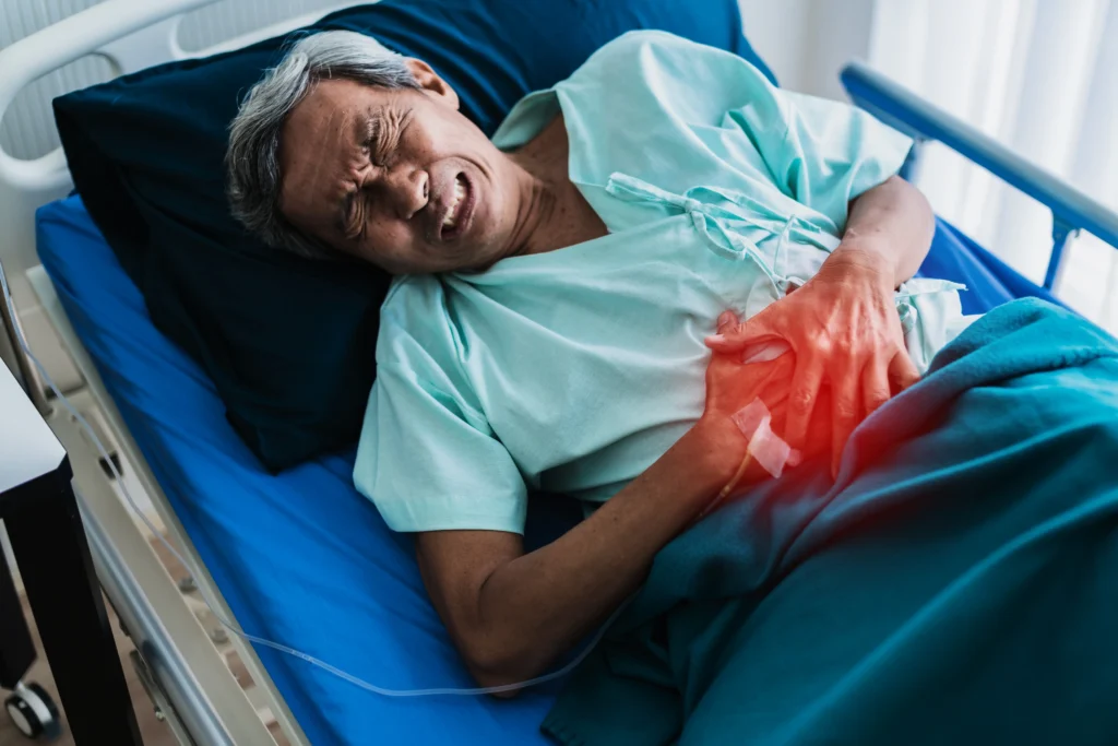 Elderly patient lying in hospital bed with severe abdominal pain, possibly due to gallbladder disease